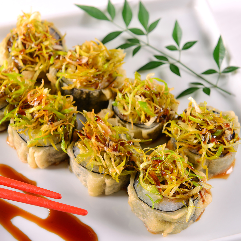 Горячие суши с овощами на белой тарелке 