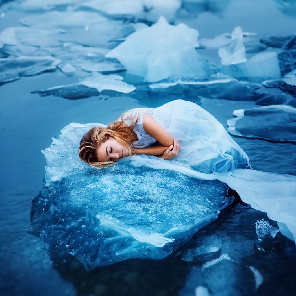 Девушка в красивом белом платье лежит на льдине