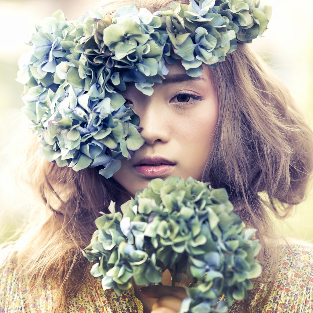 Молодая девушка азиатка с венком из цветов на голове