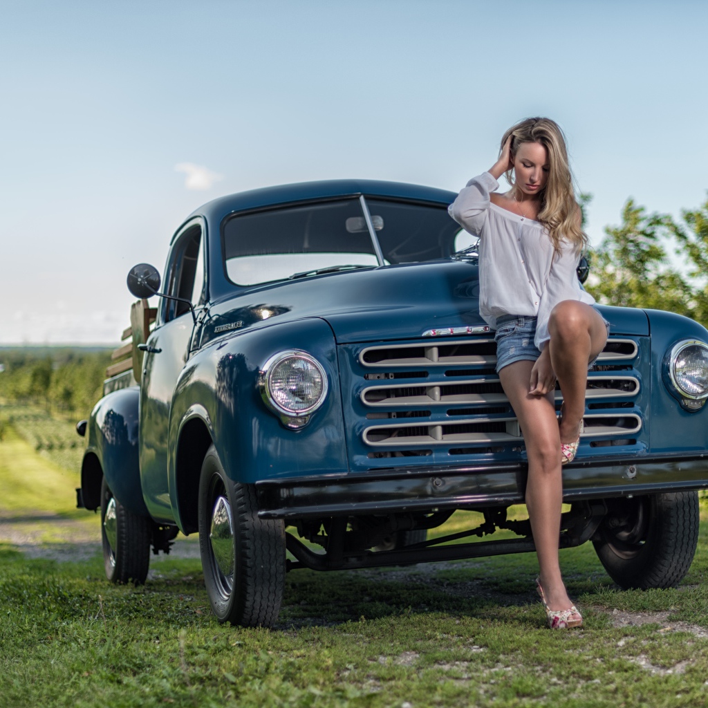 Молодая девушка стоит рядом с зеленым автомобилем Studebaker Pickup, 1953 года