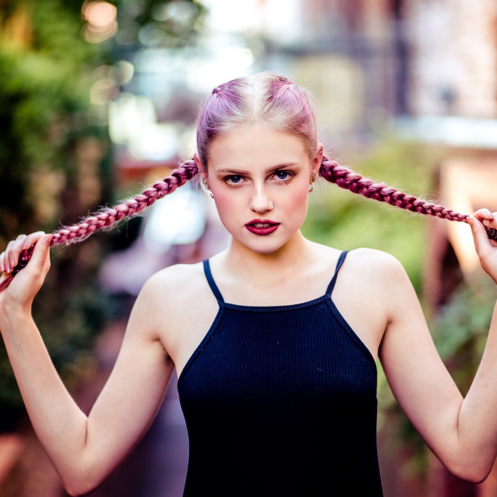 Молодая девушка с розовыми косами на голове