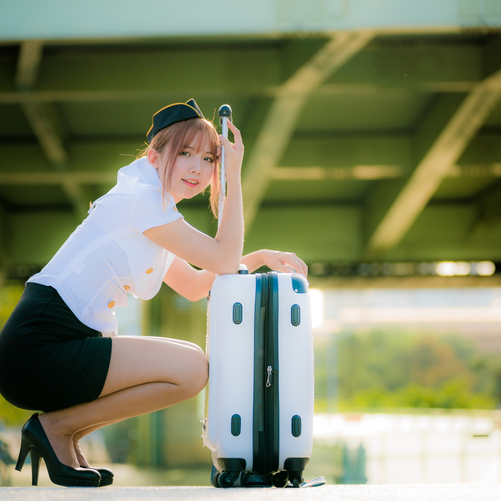 Девушка азиатка стюардесса с чемоданом