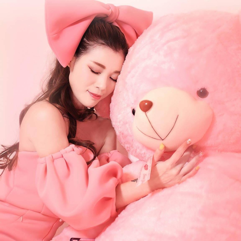 Красивая девушка азиатка с большим розовым медведем