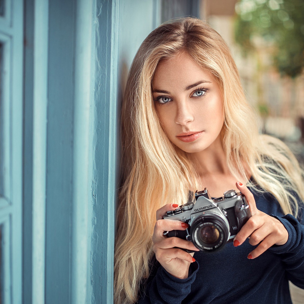 Красивая девушка блондинка с фотоаппаратом 