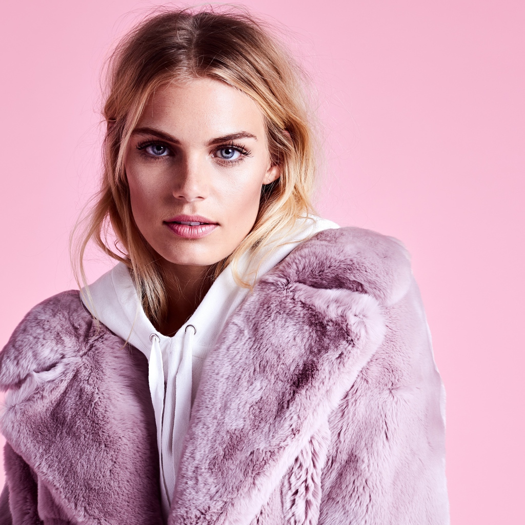 Красивая голубоглазая девушка в шубе на розовом фоне