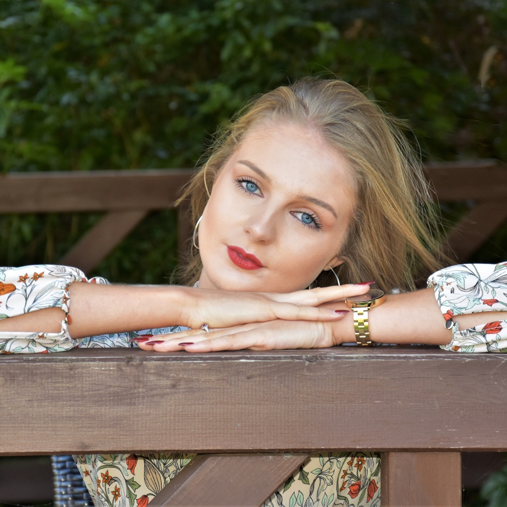 Красивая голубоглазая девушка с часами на руке