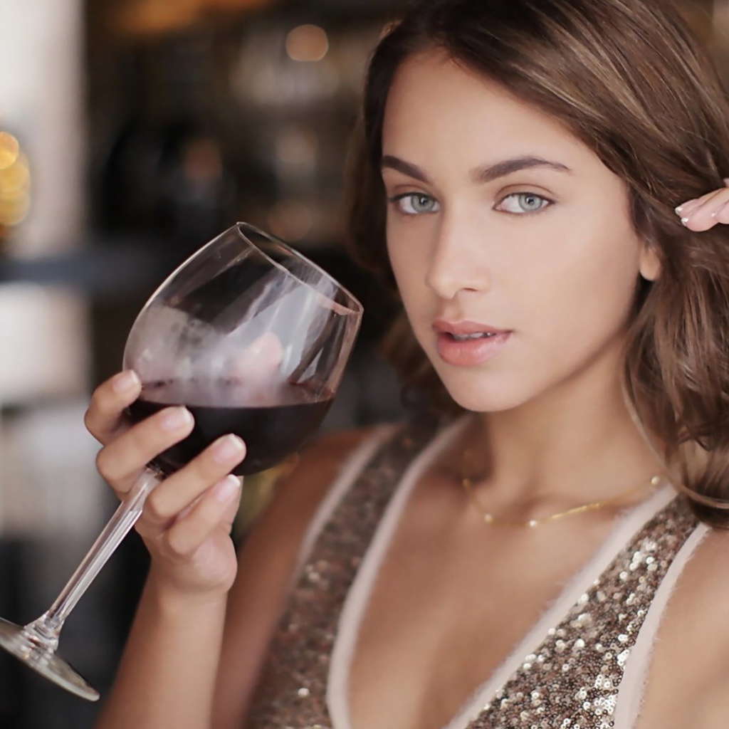 Красивая голубоглазая девушка с бокалом красного вина в руке