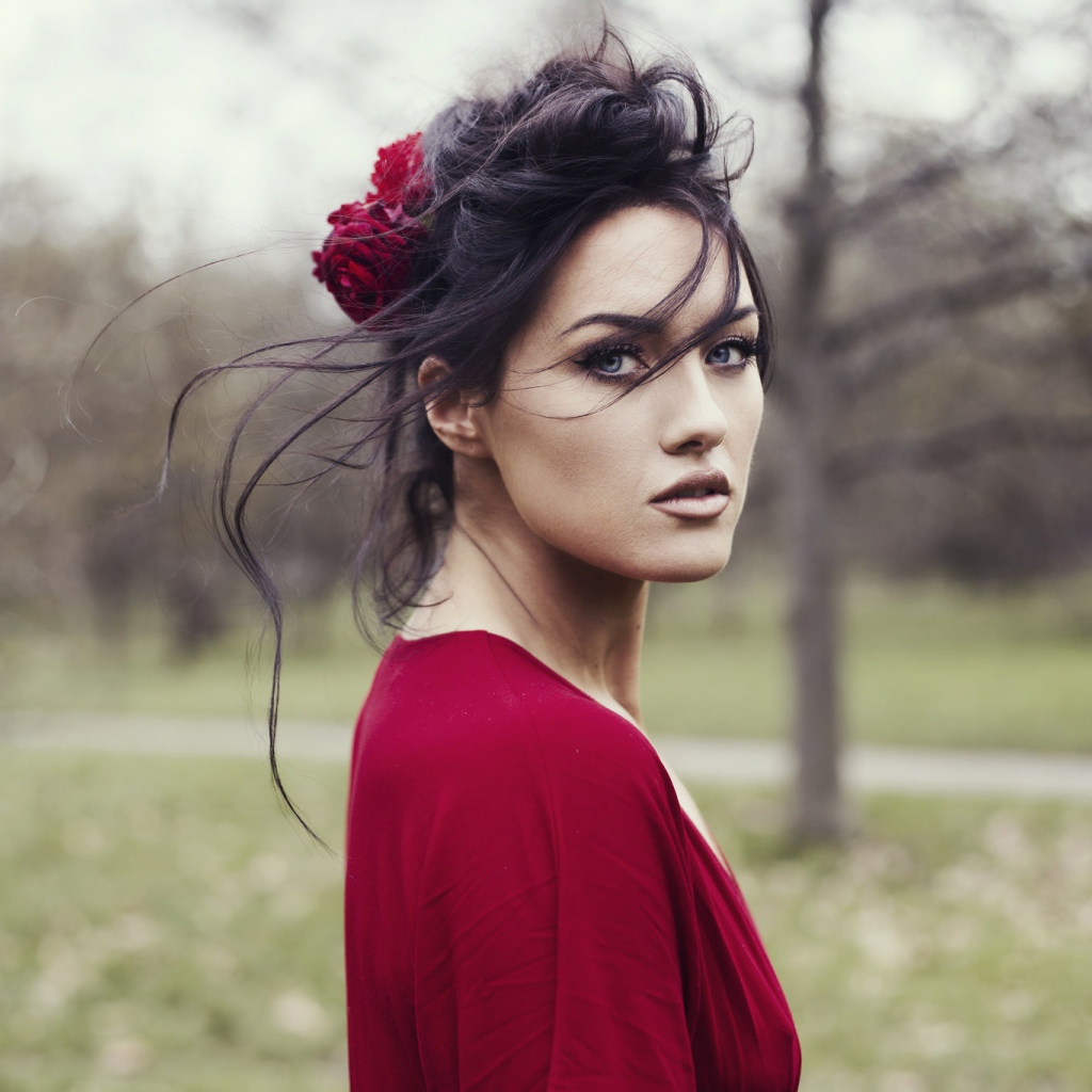 Красивая брюнетка в красном платье с цветком в волосах