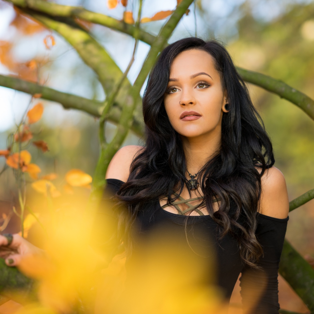 Красивая брюнетка у дерева в черном платье