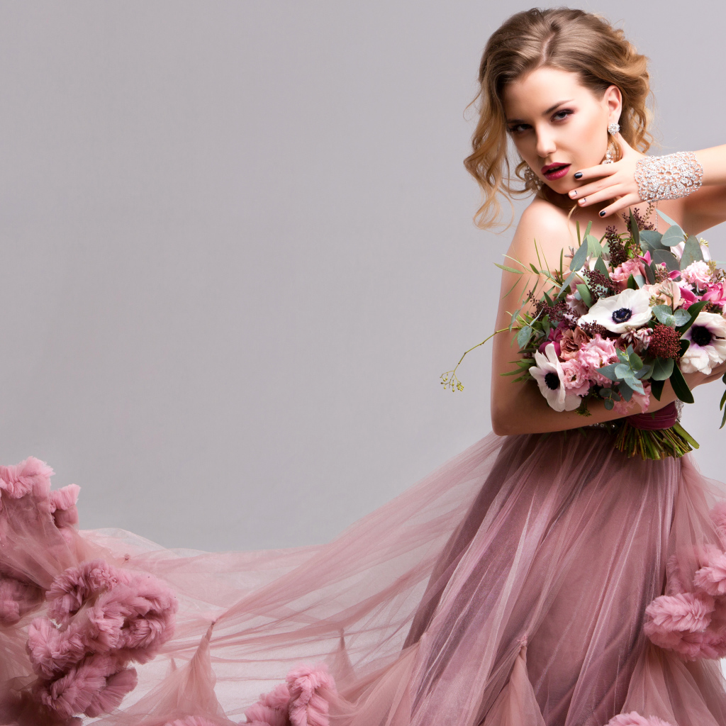 Эффектная девушка в красивом розовом платье с букетом цветов в руках