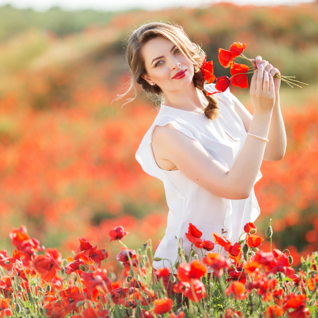 Красивая девушка в белом платье с букетом маков в руках