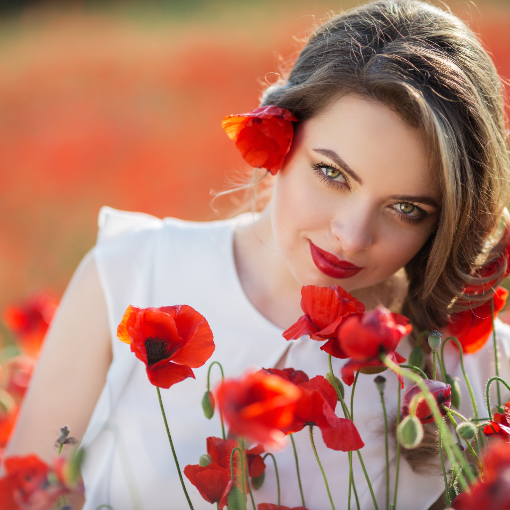 Красивая девушка с выразительным взглядом на поле с красными маками