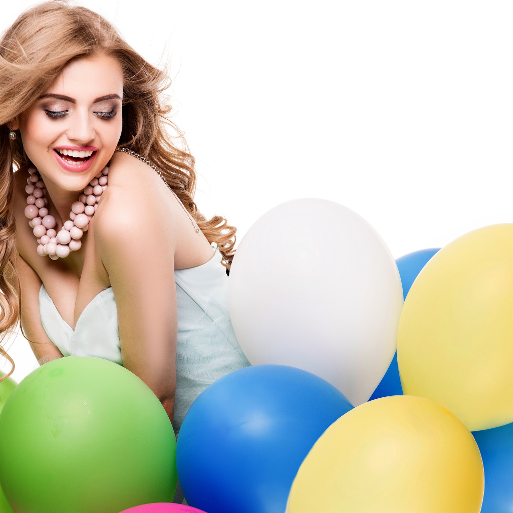 Красивая улыбающаяся девушка с разноцветными шариками на белом фоне