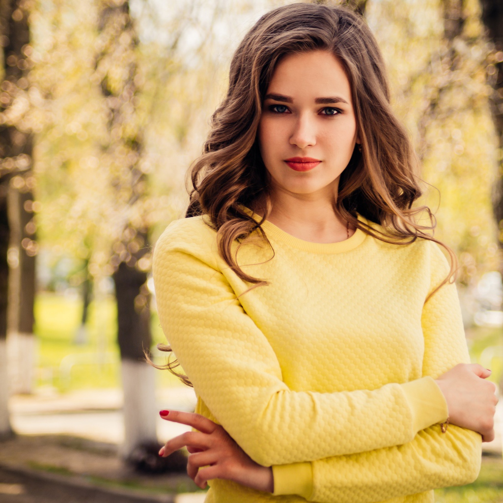 Красивая молодая голубоглазая девушка в желтом свитере