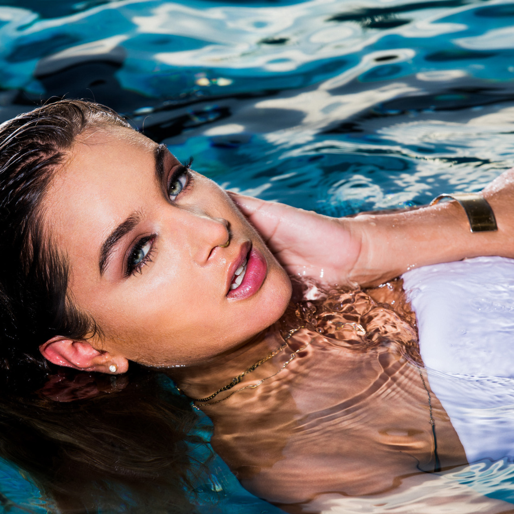 Красивая молодая девушка купается в чистой воде