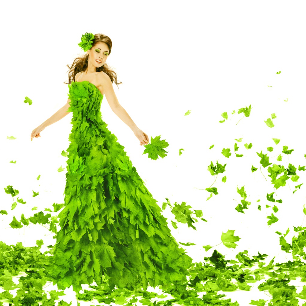 Красивая молодая девушка в платье из зеленых листьев на белом фоне