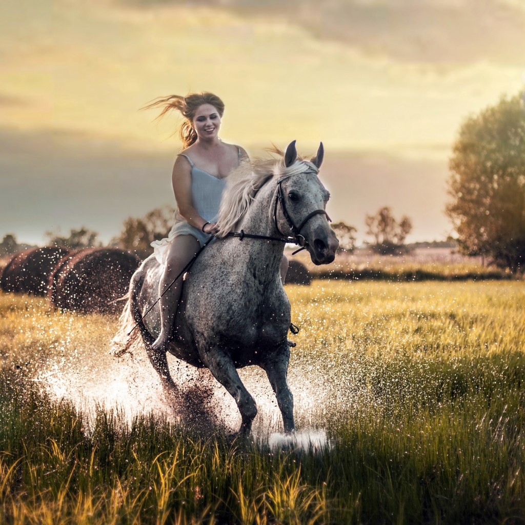 Красивая молодая девушка скачет на лошади по мокрой траве