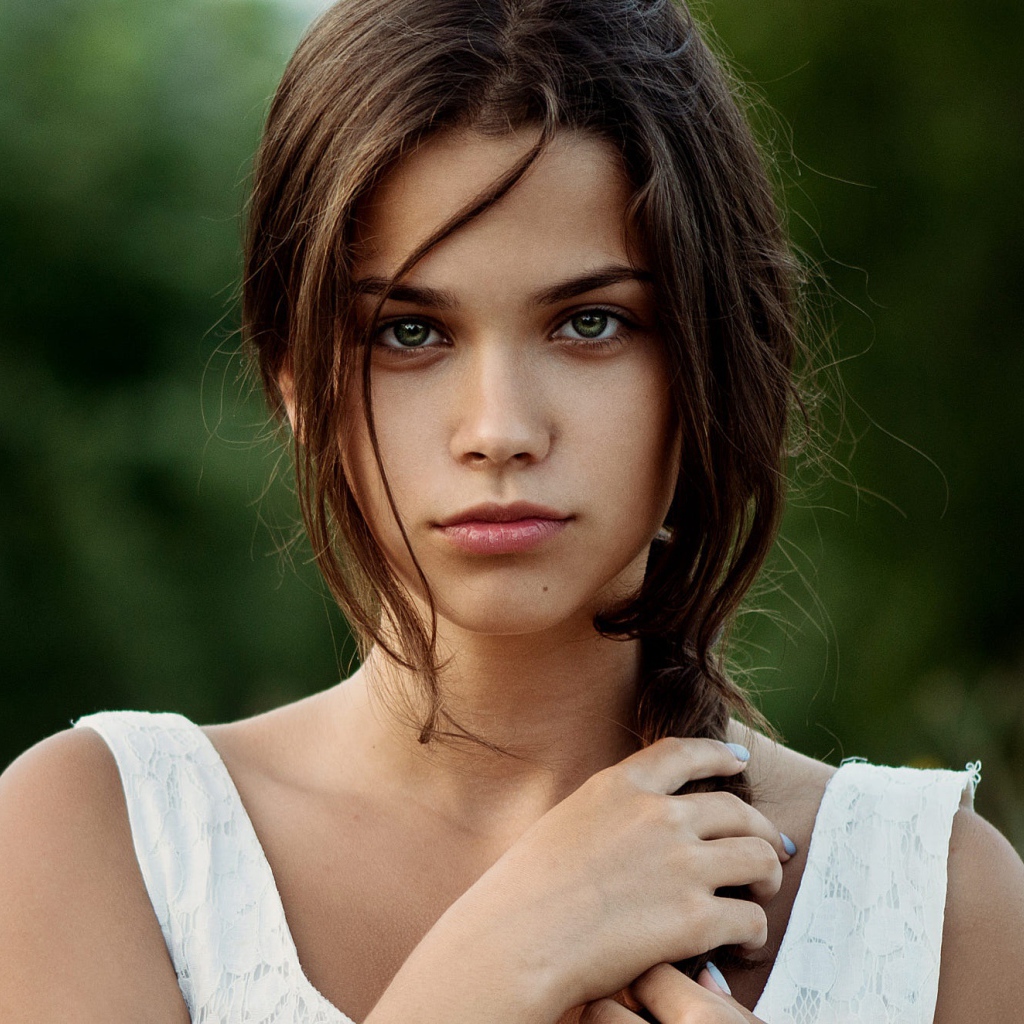 Красивая молодая зеленоглазая девушка с косой на голове