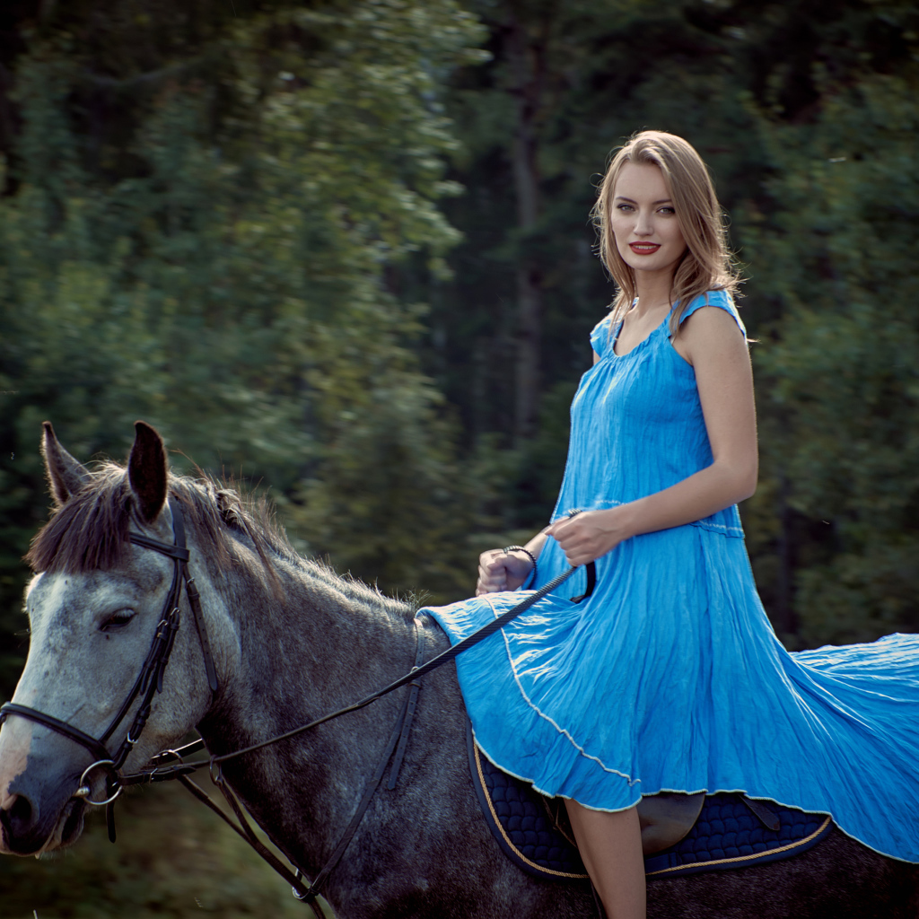 Девушка блондинка в голубом платье на лошади