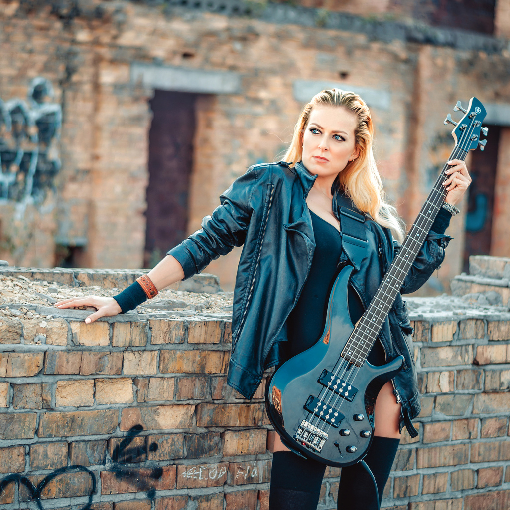 Блондинка в кожаной куртке с электрогитарой в руках