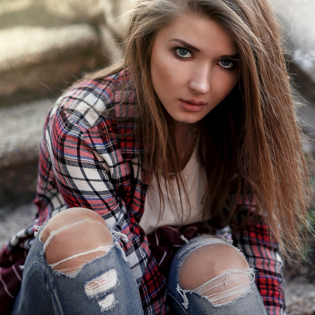 Голубоглазая девушка брюнетка в модных джинсах 