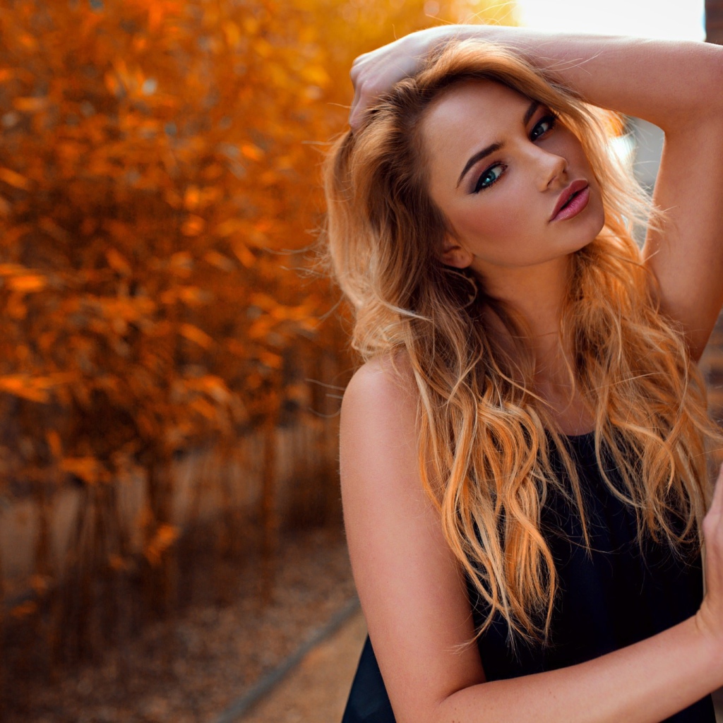 Голубоглазая девушка блондинка у стены 