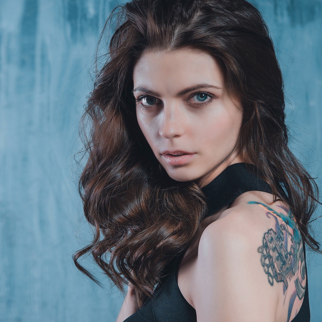 Голубоглазая девушка с татуировкой на спине 