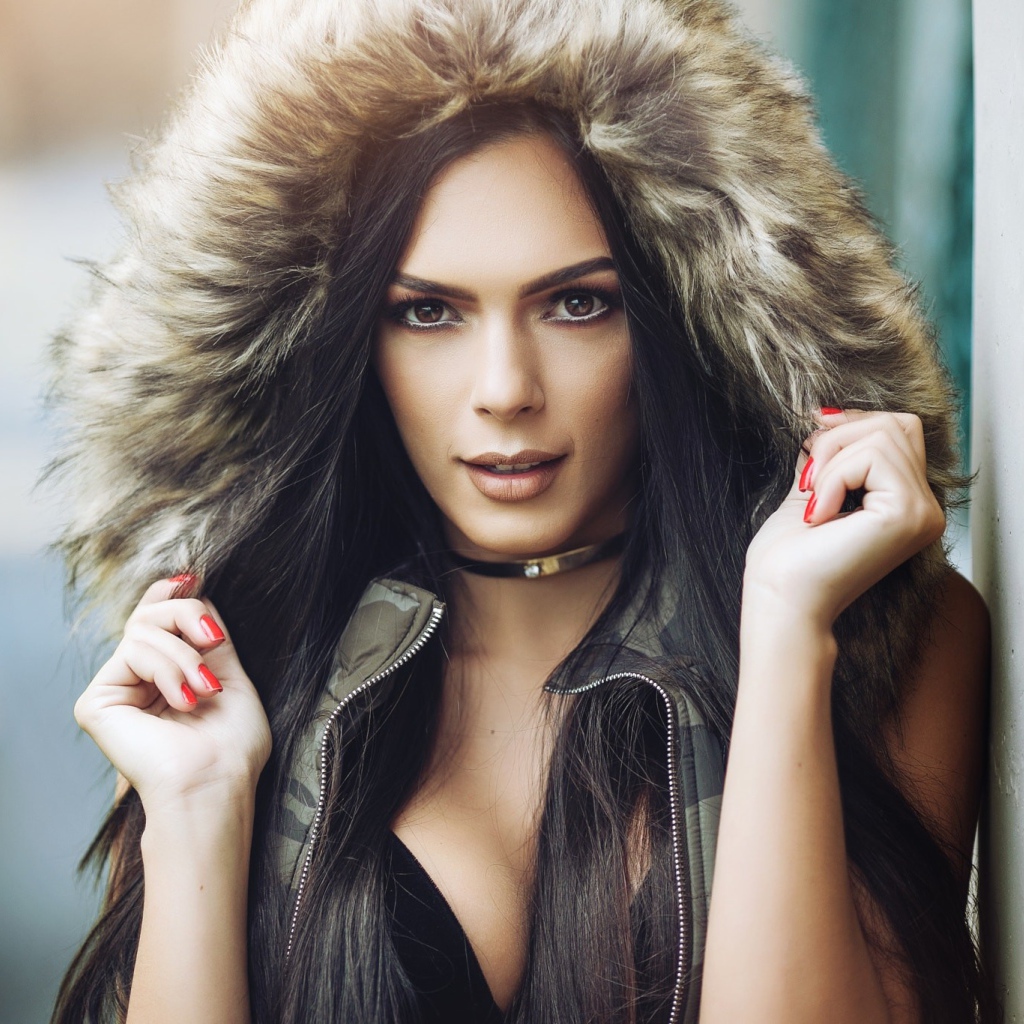 Брюнетка в капюшоне с красными ногтями на руках 