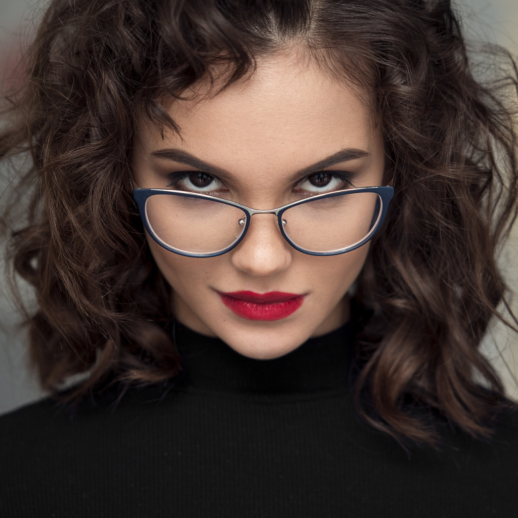 Брюнетка с красными губами с очками на лице