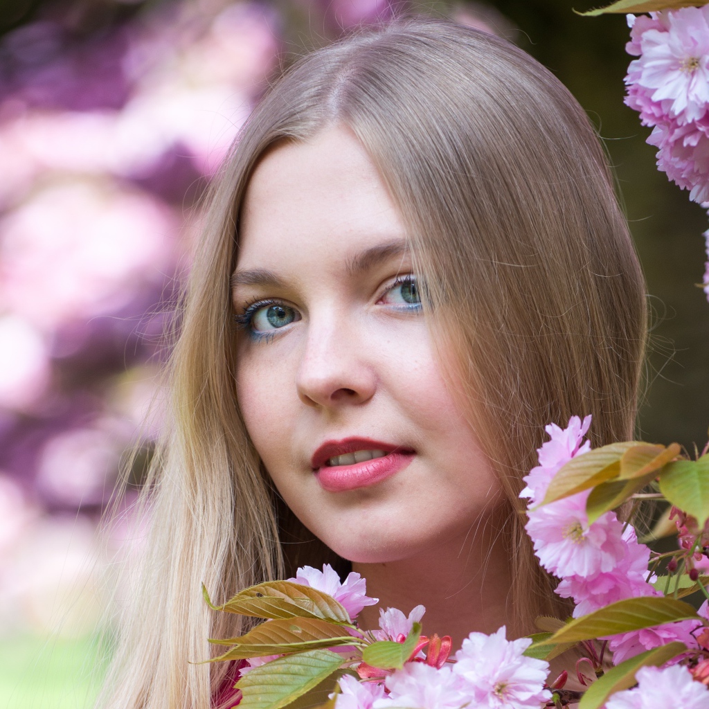 Милая голубоглазая девушка с розовыми цветами 