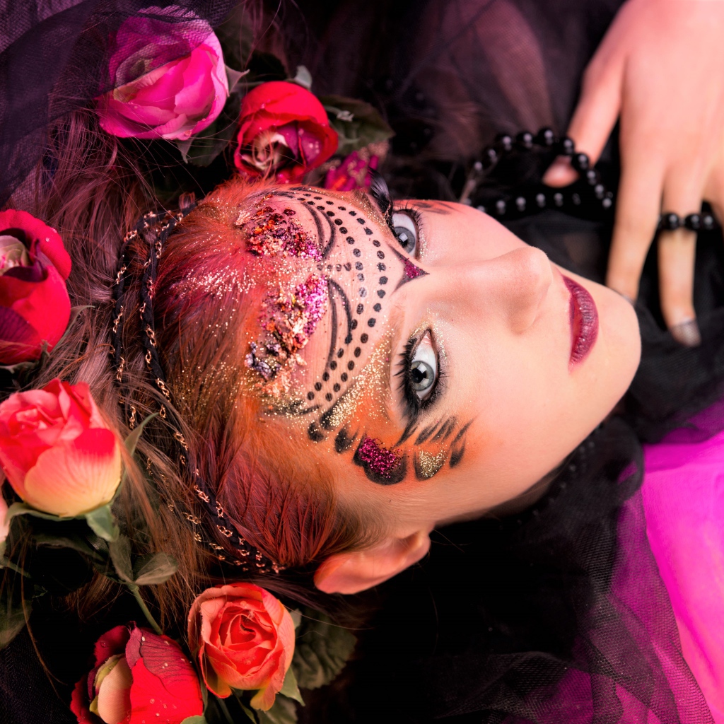 Девушка с блестящим ярким макияжем и розами в волосах