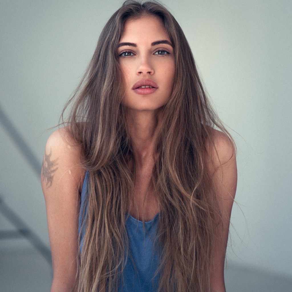 Девушка с длинными волосами и татуировкой на плече 