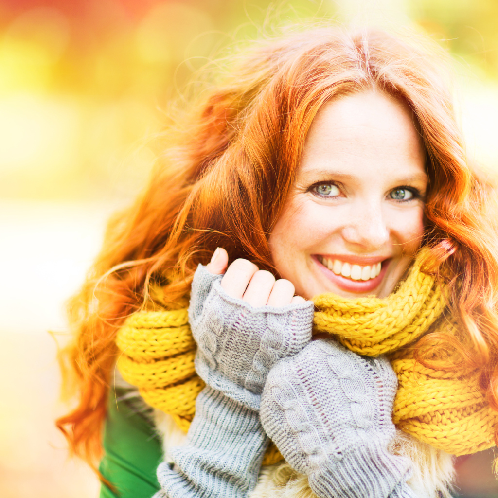 Улыбающаяся рыжеволосая девушка в теплом шарфе