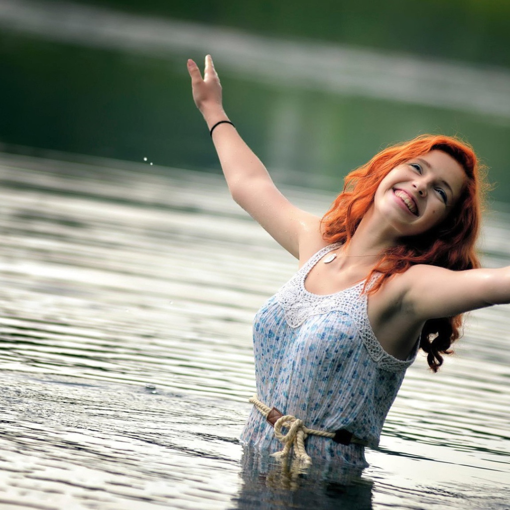 Улыбающаяся рыжеволосая девушка в воде 