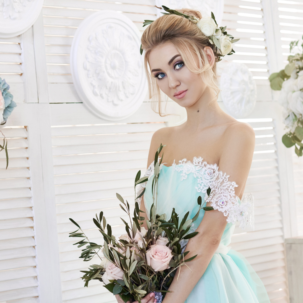 Spectacular look of a blue-eyed blonde in a beautiful dress with a bouquet of flowers