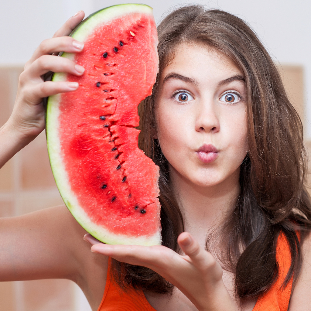 Девушка держит в руках скибку арбуза