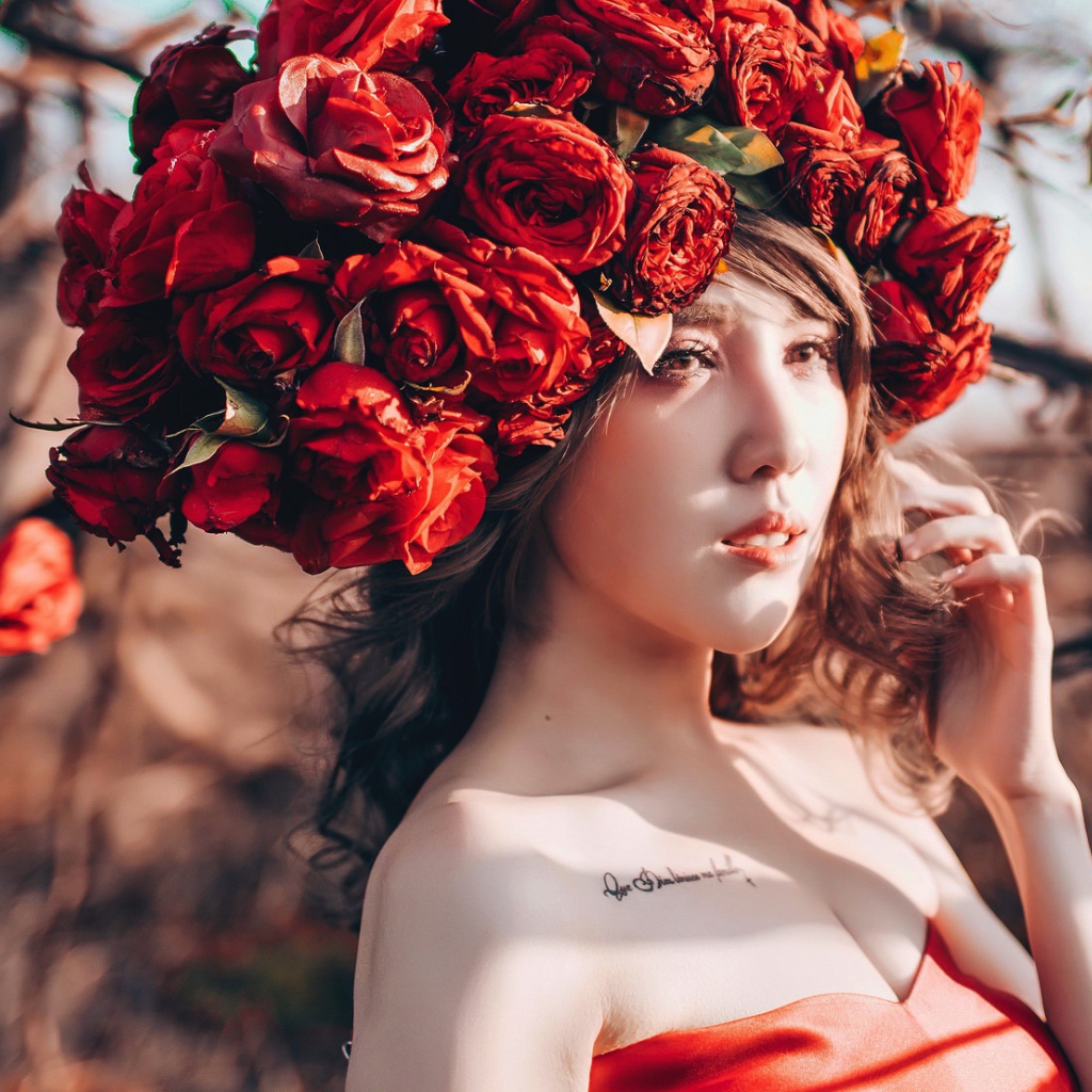 Молодая девушка азиатка с красными цветами на голове