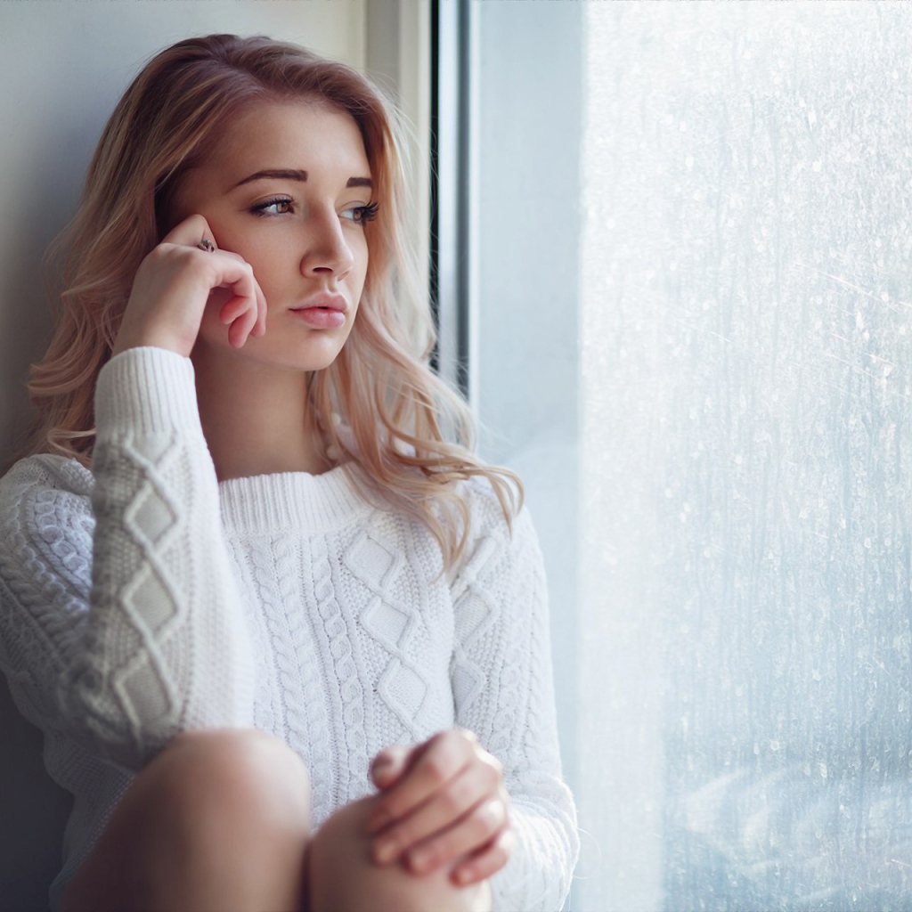 Молодая девушка блондинка у окна 