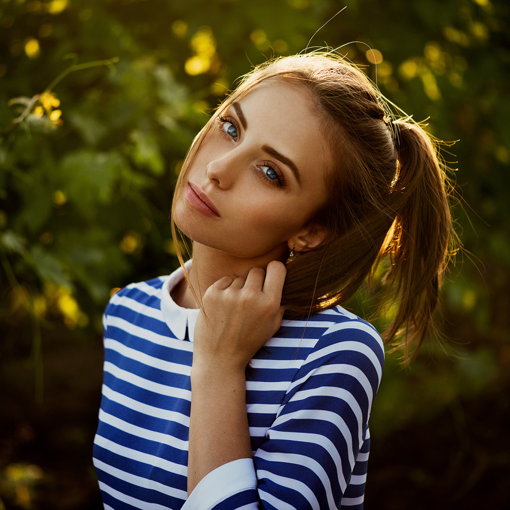 Молодая голубоглазая девушка в полосатом платье