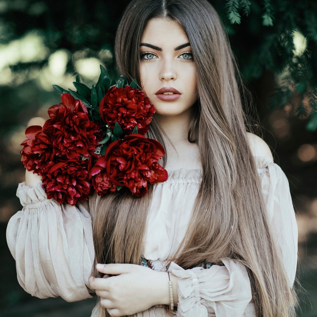 Молодая девушка с букетом бордовых пионов 