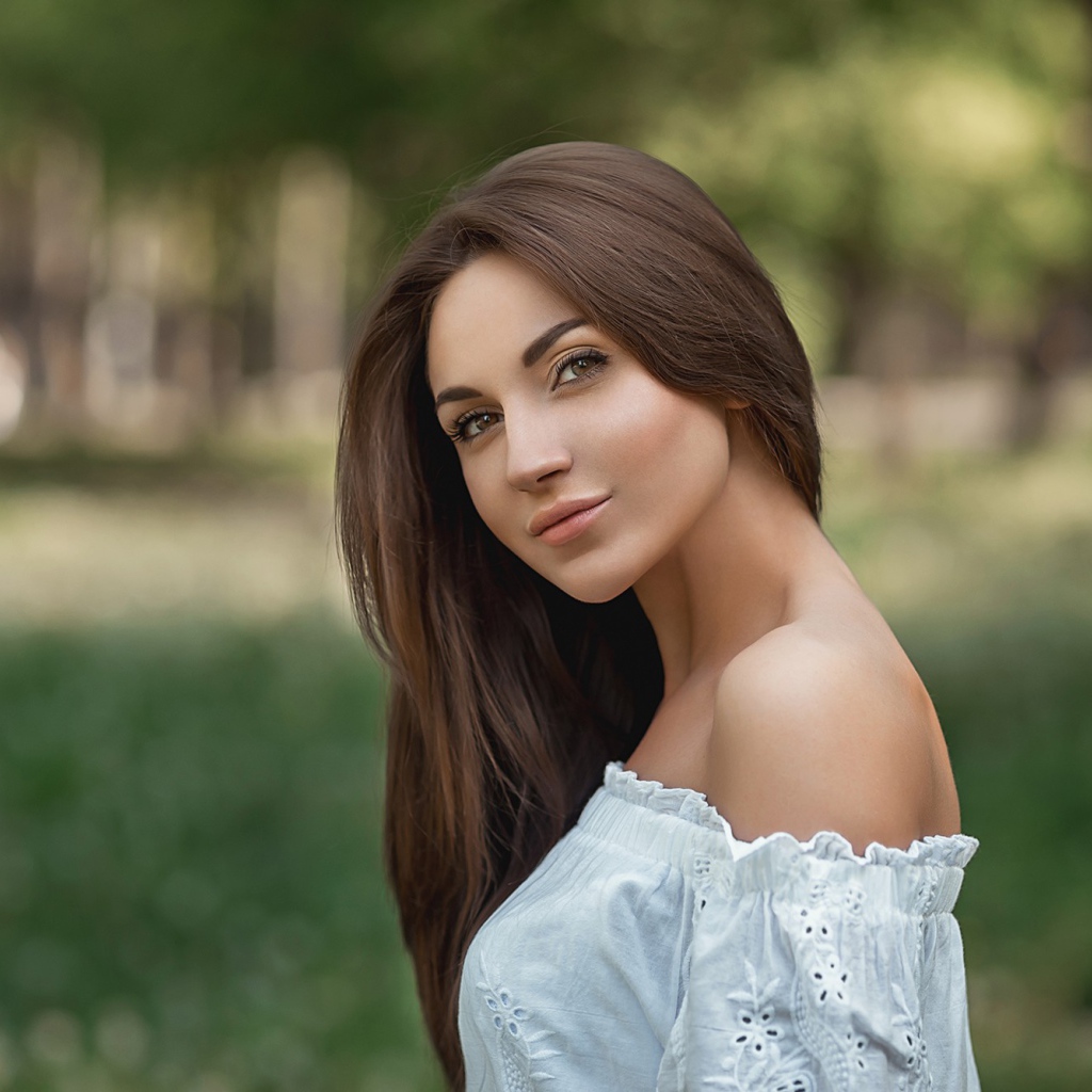 Молодая девушка с длинными волосами в белом 