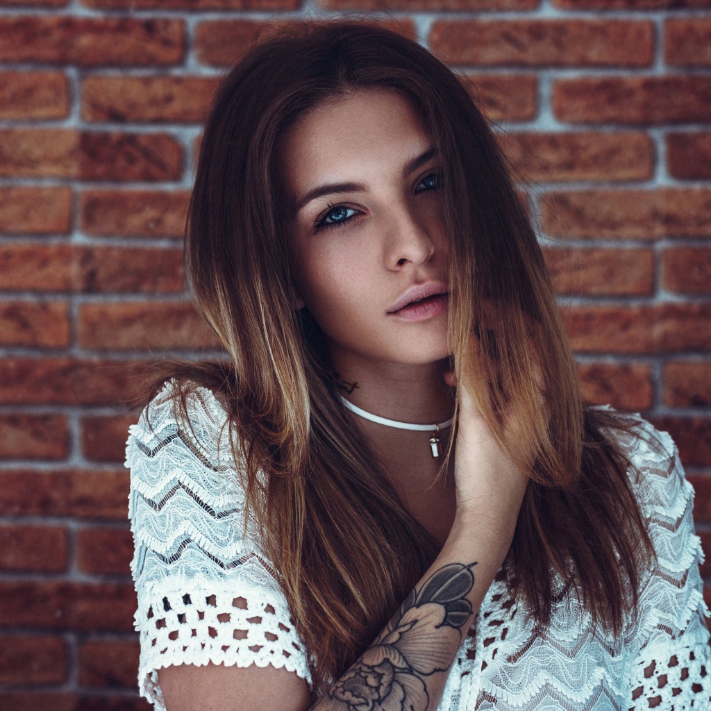 Молодая девушка с татуировкой на руке