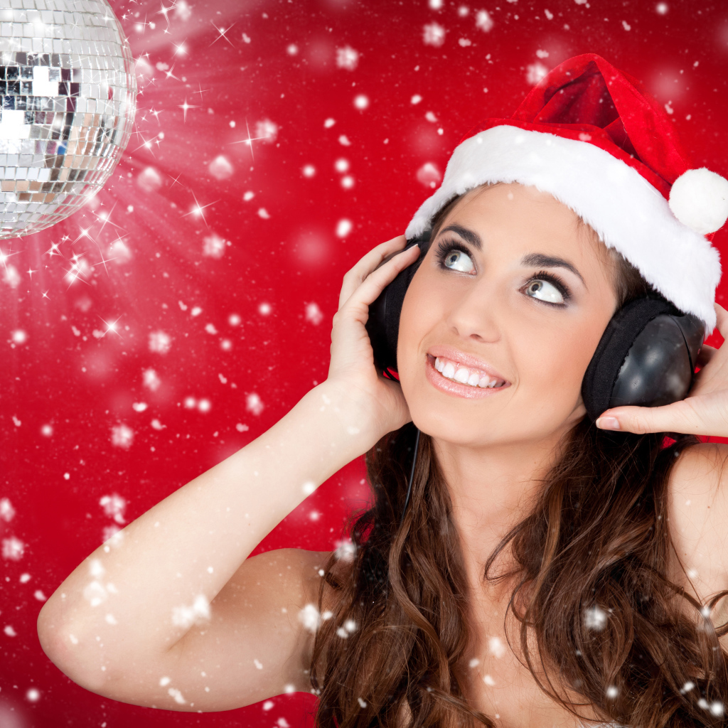 Девушка в новогодней шапке слушает музыка в наушниках