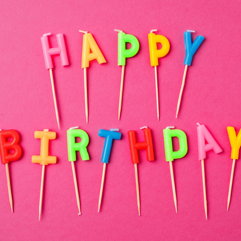 Праздничные свечи с надписью Happy Birthday на розовом фоне