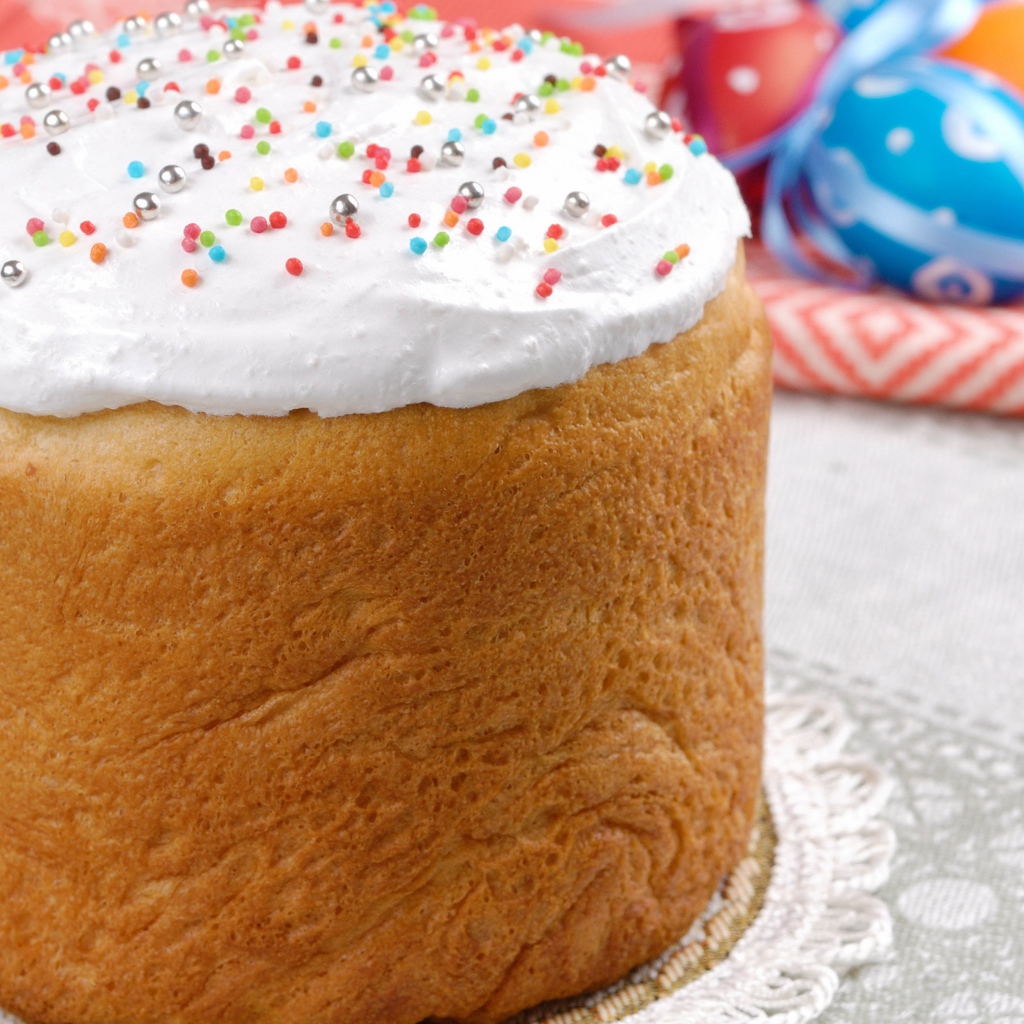 Пасхальный кулич с белой глазурью на столе 