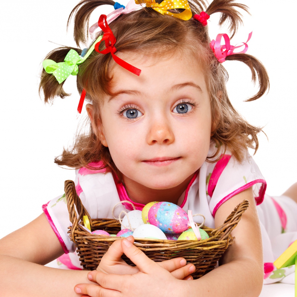 Маленькая девочка с корзинкой пасхальных яиц на белом фоне 