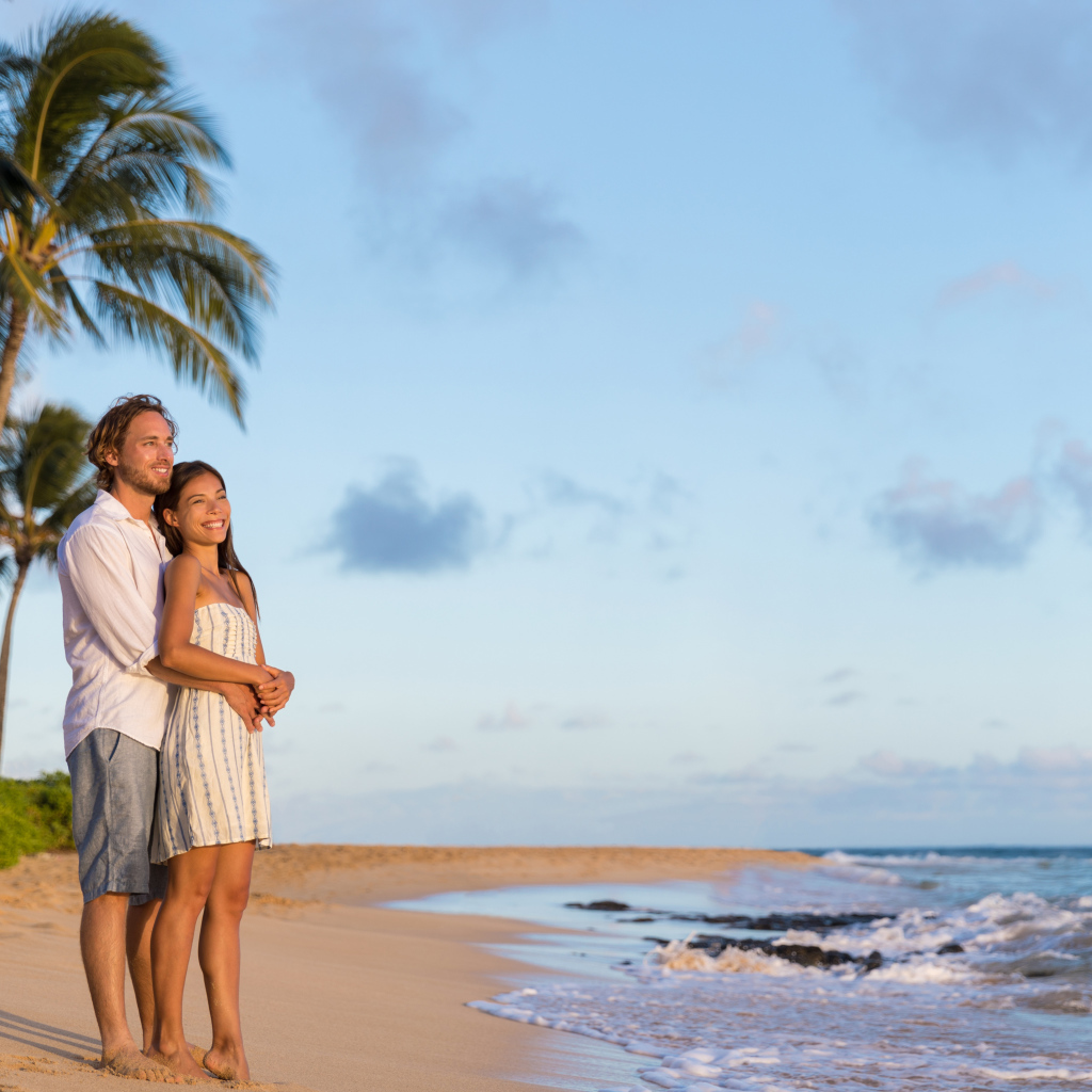 Влюбленная пара встречает закат на берегу океана