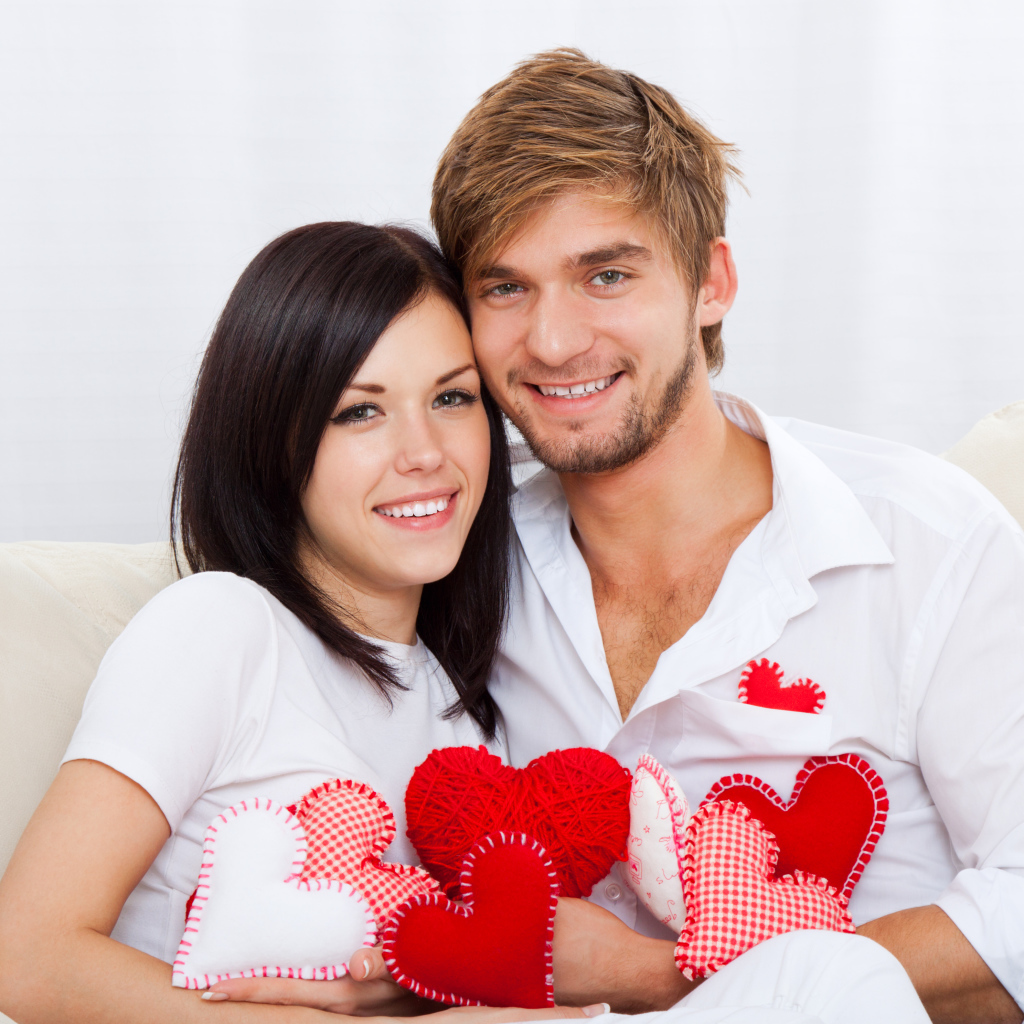 Красивая влюбленная пара с маленькими сердечками в руках