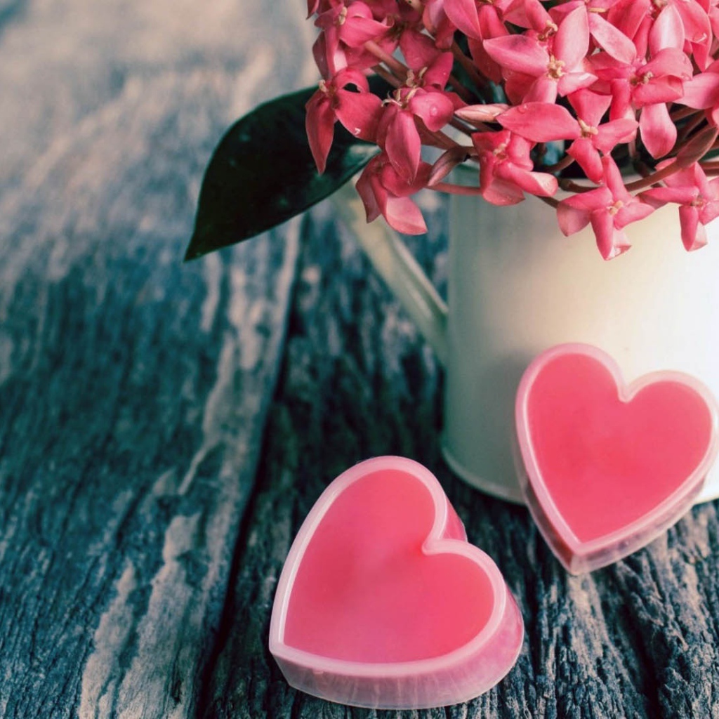 Розовые цветы в белой вазе и два розовых сердца 