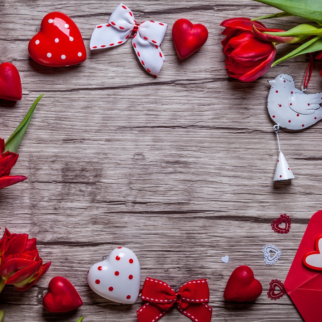 Красные тюльпаны с сердечками и бантиками на деревянной поверхности